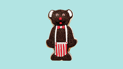 This is a digital art illustration of a cartoon-style gingerbread man character. The character has brown fur and wears a white shirt with red stripes on the sleeves, a black bow tie, blue pants with red stripes, and a red hat. It also wears glasses and is holding a cane in one hand.